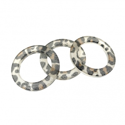 Três pulseiras redondas com padrão animal print em tons de cinza, branco e castanho claro