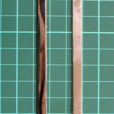 Estrutura retangular metálica prateada sobre fundo verde com grelha