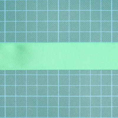 Fita verde de tecido sobre superfície azul quadriculada