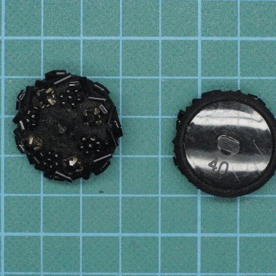 Dois botões pretos redondos sobre superfície quadriculada azul