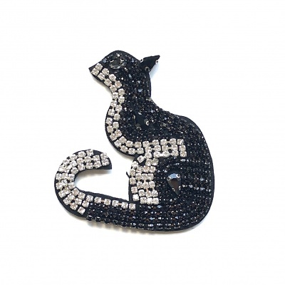 Broche de gato com pedras pretas e brancas sobre fundo branco