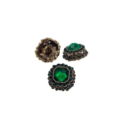 Três botões metálicos vintage com pedras verdes facetas em fundo branco