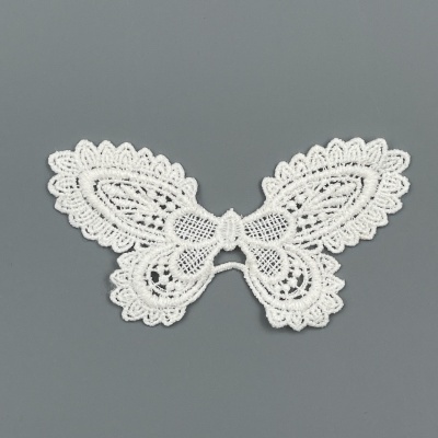 Aplicação em renda branca em forma de borboleta sobre fundo cinza
