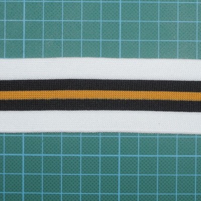 Elástico branco com riscas preta e castanha sobre fundo verde quadriculado