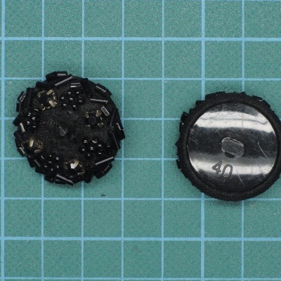 Dois botões pretos sobre superfície azul quadriculada