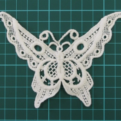 Aplicação de renda branca em forma de borboleta sobre grelha verde
