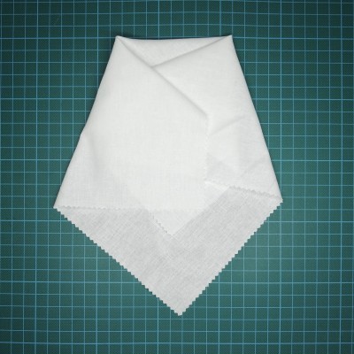 Toalhete ou guardanapo branco em tecido sobre superfície quadriculada verde