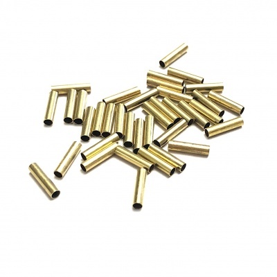 Múltiplos tubos metálicos dourados pequenos em fundo branco.