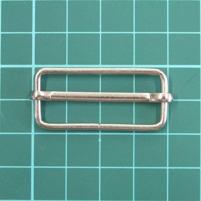 fivela metálica retangular prateada com barra central em fundo verde quadriculado