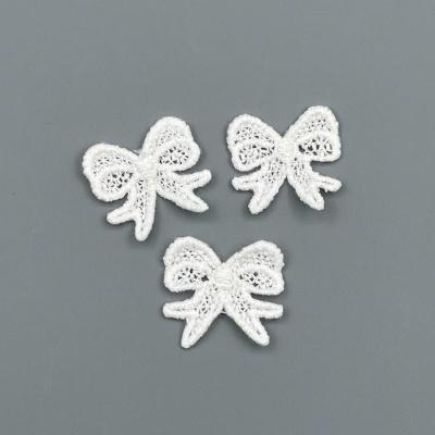 Três laços de renda branca sobre fundo cinza