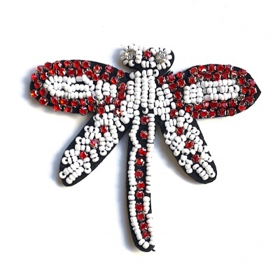Broche em forma de libélula com contas brancas e vermelhas sobre base preta