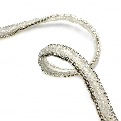 Fita decorativa de cristais e metal prateado sobre fundo branco