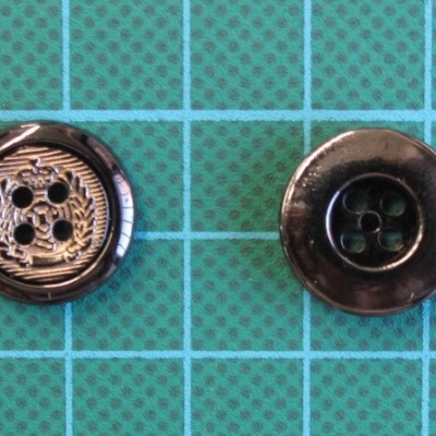 Dois botões redondos pretos sobre fundo verde quadriculado azul