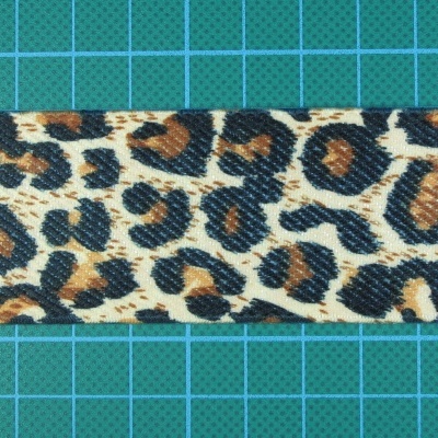 Faixa têxtil com estampa leopardo sobre superfície verde quadriculada