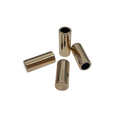 Quatro tubos metálicos dourados cilíndricos com interior negro