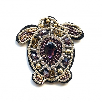 Broche tartaruga com pedrinhas brilhantes em tons roxo, dourado e prata