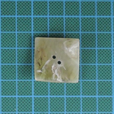 Botão quadrado creme com efeito madrepérola em fundo quadriculado azul