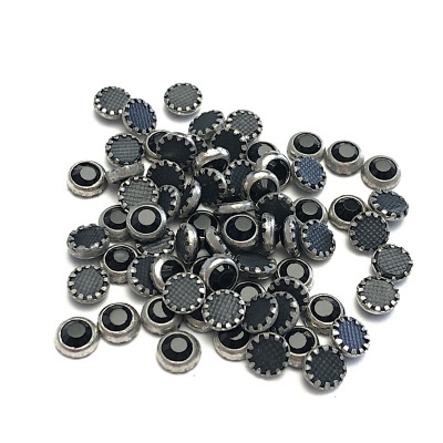 Vários botões redondos pequenos prateados com topo preto e diferentes padrões