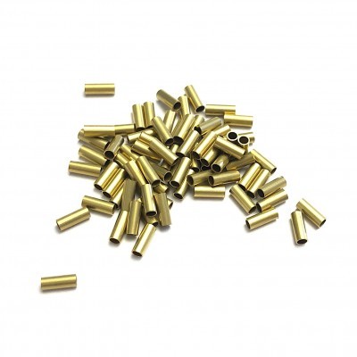 Pequenos tubos cilíndricos dourados dispersos sobre fundo branco