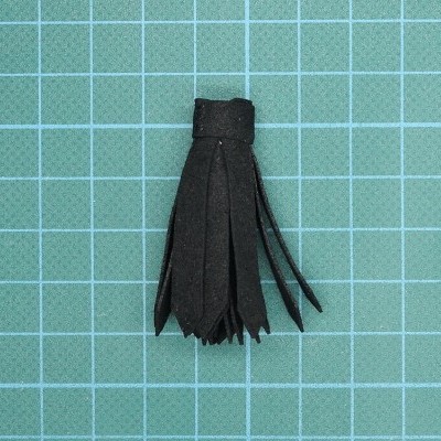 Franja preta de material tipo couro sobre fundo quadriculado azul claro