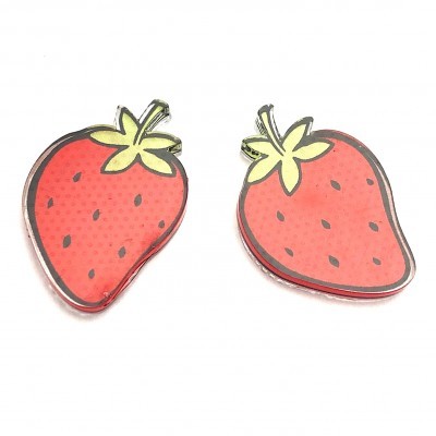 Dois broches em forma de morango vermelho com folhas verdes sobre fundo branco
