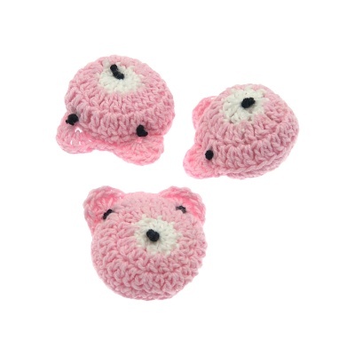 Três brinquedos pequenos de croché rosa em forma de cabeça de animais
