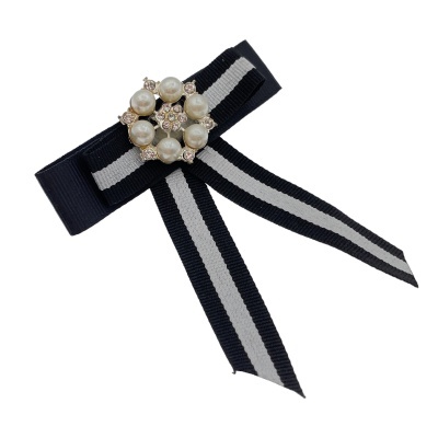 Laço preto com risca branca e broche com pérolas e cristais