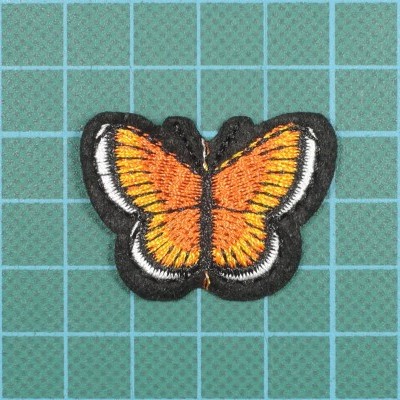 Aplicação em tecido em forma de borboleta com asas laranja e contorno preto