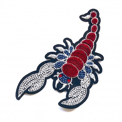 Aplicação têxtil bordada em forma de escorpião
