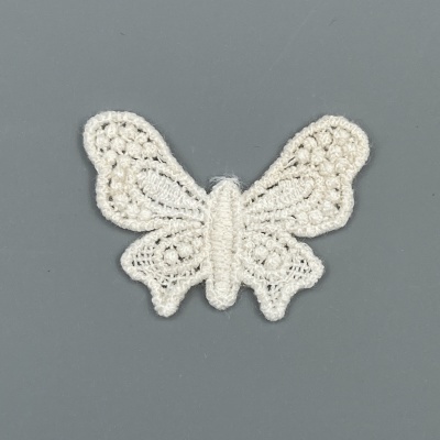 Aplicação em forma de borboleta de croché branco sobre fundo cinzento