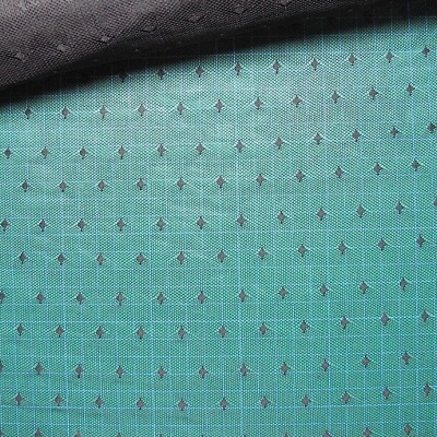 Tecido verde com padrão de setas pretas e tecido preto