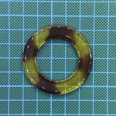 Anel redondo castanho e amarelo sobre fundo de grade azul