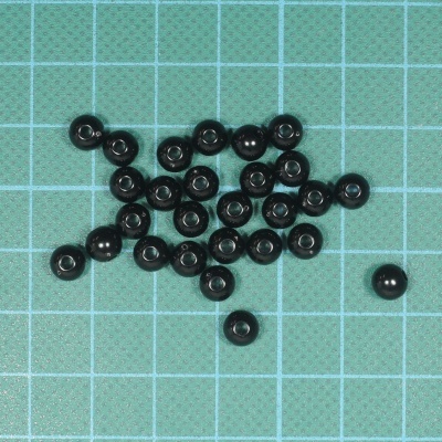 Esferas pequenas pretas sobre superfície quadriculada verde