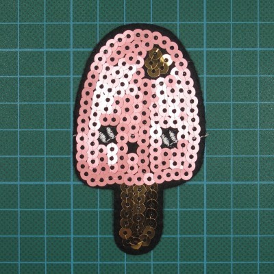 Aplicação de gelado rosa com lantejoulas sobre base de corte verde