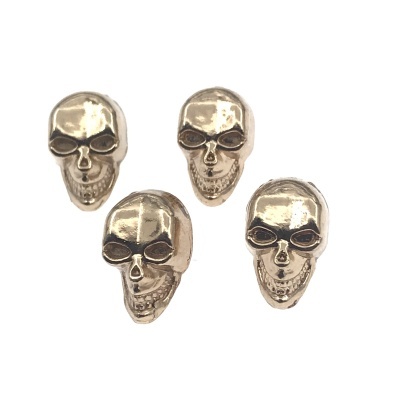 Botões prateados em forma de caveira com detalhes em relevo em fundo branco