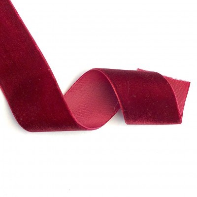 Fita de veludo vermelho com textura macia num fundo branco