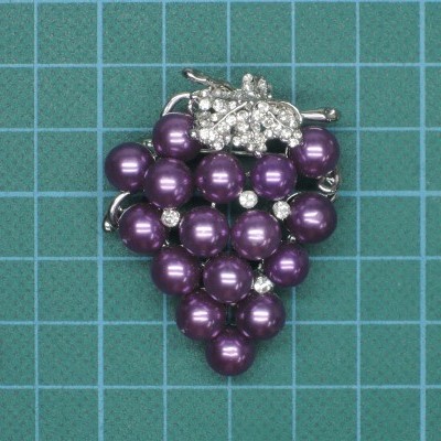 Broche em forma de cacho de uvas com pérolas roxas e detalhes brilhantes
