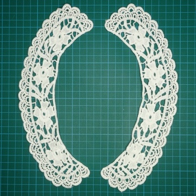 Colar de renda branca floral em duas partes sobre fundo verde quadriculado