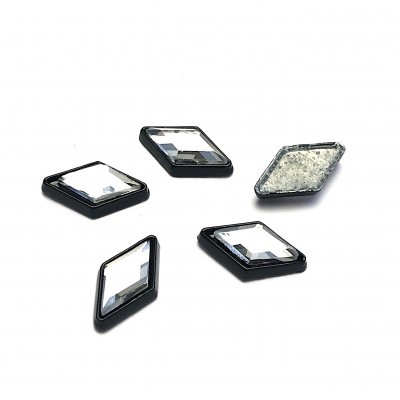 Peças decorativas em forma de losango com bordas pretas e centro transparente