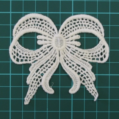 Laço de renda branca com padrão detalhado em fundo verde de grade