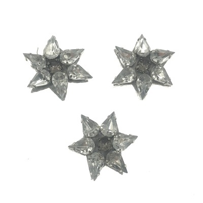 Brincos estrela prateados com pedras transparentes em fundo branco