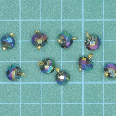 Pendentes pequenos facetados azuis com reflexos multicoloridos em superfície quadriculada azul