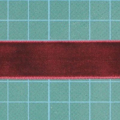 Fita vermelha de veludo sobre fundo quadriculado verde