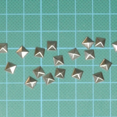 Tachas de metal prateado em superfície azul quadriculada