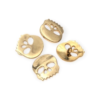 Botões dourados em forma de caveira em fundo branco