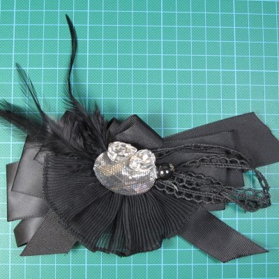 Acessório de cabelo decorativo preto com plumas e aplicação prateada