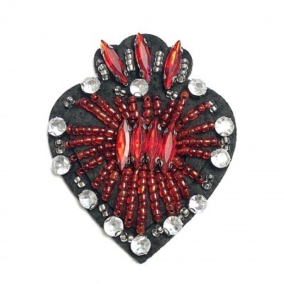 Broche em formato de coração com contas vermelhas e cristais transparentes sobre base preta