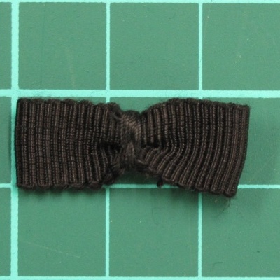 Laço preto de tecido sobre superfície verde quadriculada