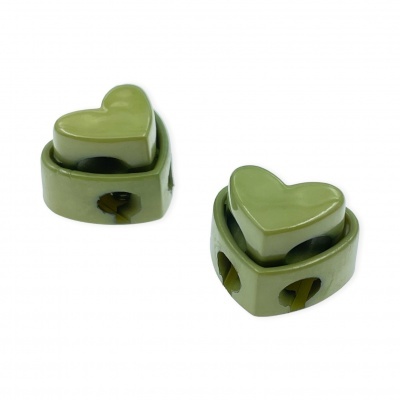 Dois objetos verdes em forma de coração com furos laterais em coração