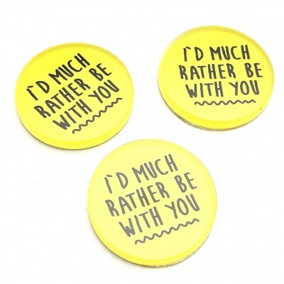 Três crachás redondos amarelos com texto em inglês a preto